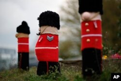 A view of knitted Grenadier Guards figures made by members of the 'Hurst Hookers' knitting group after their fitting to posts during a pre-coronation 'yarn bombing' in the village of Hurst, near Reading, England, April 21, 2023.