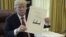 El presidente Donald J. Trump muestra un documento el día de la firma de la Ley de Recorte y Reforma de Impuestos en la Oficina Oval, el 22 de diciembre de 2017.