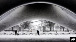 با ادامه ریزش برف کارکنان پارک هزاره در شیکاگو مجسمه فولادین "دروازه ابر" کار انیش کوپر را برف روبی می کنند، ۲ ژانویه ۲۰۱۴