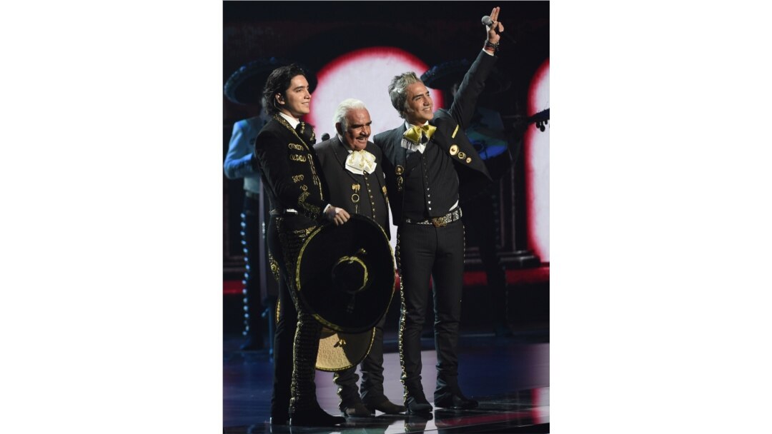 En esta fotografía del 14 de noviembre de 2019 Vicente Fernández, centro, su hijo Alejandro Fernández, derecha, y su nieto Alex Fernández saludan su presentación en los Latin Grammy en el MGM Grand Garden Arena en Las Vegas.