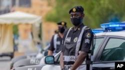 Policemen wearing gloves and face masks to help prevent the spread of the coronavirus, provide security for pilgrims, in Mecca, Saudi Arabia, Sunday, July 26, 2020. Only about 1,000 pilgrims will be allowed to perform the annual hajj pilgrimage that…