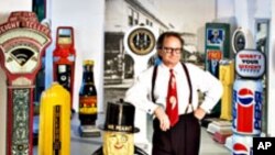 In his artist's studio, Christopher Steele strikes a rakish pose among his collection of vintage penny scales – some dispense fortunes and trinkets