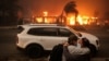 Warga tampak berpelukan saat mereka berupaya mengevakuasi wilayah Altadena, California, menyusul kebakaran hutan yang meluas di negara bagian tersebut pada 8 Januari 2025. (Foto: Reuters/David Swanson)