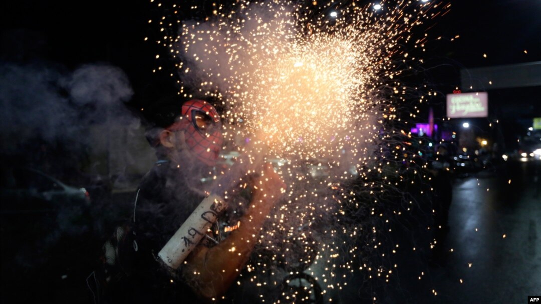 An anti-government demonstrator with a Spiderman mask fires a home-made mortar during a protest demanding Nicaraguan President Daniel Ortega and his wife, Vice President Rosario Murillo, stand down, in Managua on May 26, 2018.