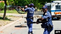 FILE - South African policemen fire rubber bullets at protesters in Mothotlung, Jan. 14, 2014.