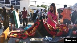 Seorang perempuan menemani kerabatnya yang terluka di luar rumah sakit setelah gempa mengguncang Desa Sembalun Selong di Lombok Timur, 29 Juli 2018. (Foto: Zakir/ Antara via Reuters)