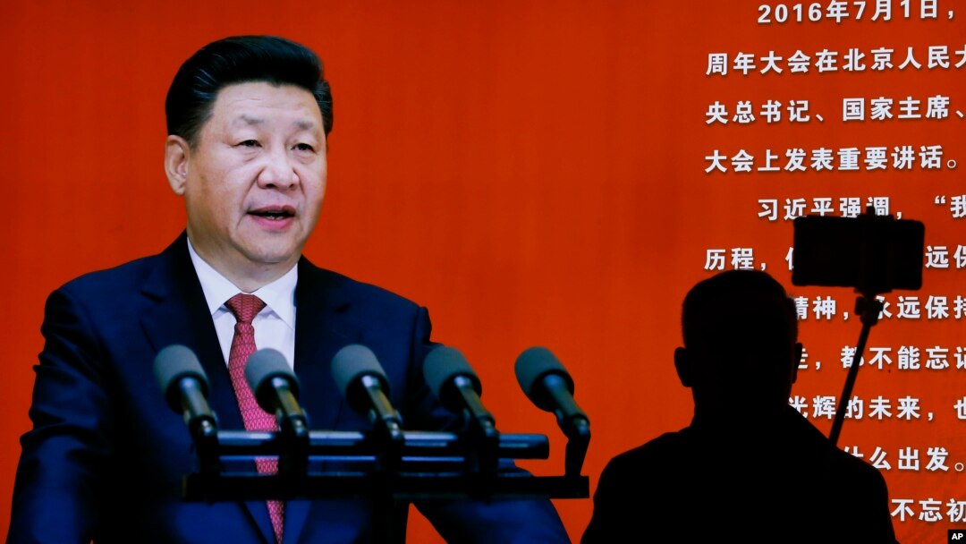 Seorang pengunjung museum militer di Beijing mengambil swafoto dekat gambar Presiden China Xi Jinping (24/10). (AP/Andy Wong)