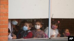 Estudiantes asisten a su primer día de regreso al aprendizaje en persona en medio de la pandemia de COVID-19 en la escuela pública Emma Villegas en Bogotá, Colombia, el lunes 24 de enero de 2022.