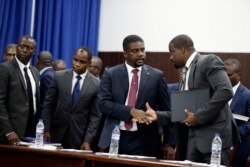 Haiti's Prime Minister-designate Fritz William Michel, center, talks to his advisor Wilfrid Theodore, right, after his speech in the parliament, in Port-au-Prince, Haiti, Sept. 3, 2019.
