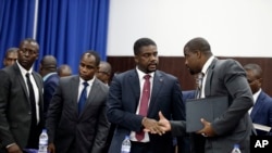 Haiti's Prime Minister-designate Fritz William Michel, center, talks to his advisor Wilfrid Theodore, right, after his speech in the parliament, in Port-au-Prince, Haiti, Sept. 3, 2019. 