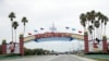 FILE - The road to the entrance of Walt Disney World is nearly empty as the theme park has been closed since mid-March because of the new coronavirus, in Lake Buena Vista, Fla., March 16, 2020.