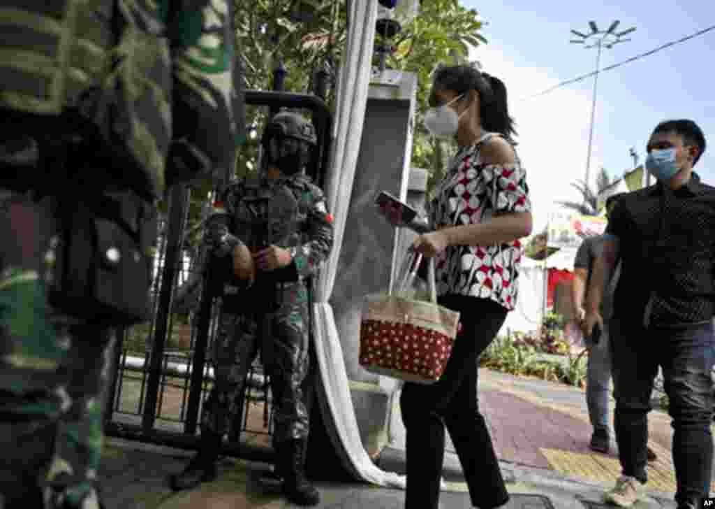 In the wake of a church attack in South Sulawesi on March 28, soldiers check worshippers at the entrance of the St. Mary of the Assumption Cathedral during Mass on Good Friday, in Jakarta, Indonesia.