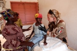 FILE - A member of a French military medical unit provides medical action for the benefit of the population during Operation Barkhane in Ndaki, Mali, July 29, 2019.