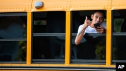 ARCHIVO - Un migrante es trasladado desde Texas a Martha's Vinyard, EEUU, en un autobús escolar.