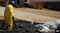 A worker cleans up oil in Mayflower, Ark., on Monday, Apr. 1, 2013, days after a pipeline ruptured and spewed oil over lawns and roadways.