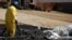 A worker cleans up oil in Mayflower, Ark., on Monday, Apr. 1, 2013, days after a pipeline ruptured and spewed oil over lawns and roadways.