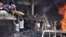 In this photo released by the Syrian official news agency SANA, Syrians carry the body of a victim from a building damaged in twin bombings struck Kurdish town of Qamishli, July 27, 2016.