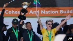 FILE - South Africa's Women's Soccer Team captain Janine van Wyk, right, with Refiloe Jane, middle, celebrates during the team victory welcome at the OR Tambo International Airport in Johannesburg, South Africa, Tuesday, July 26, 2022,