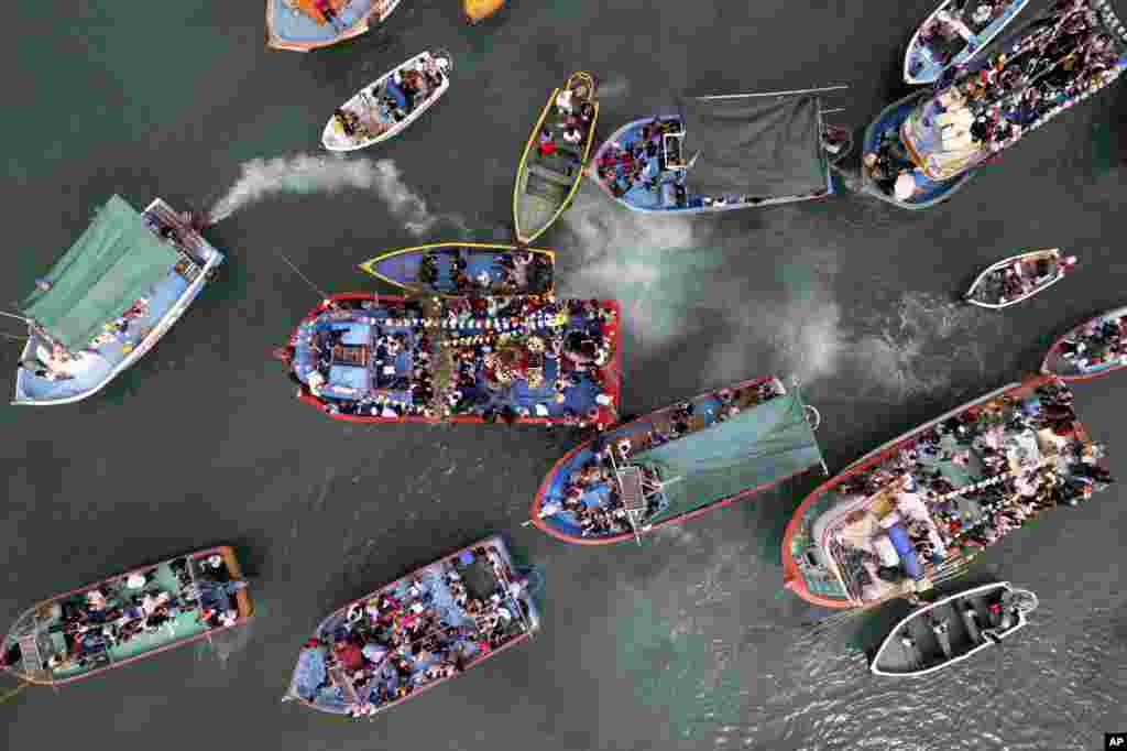 Pescadores van en procesión detrás de la representación de San Pedro, transportada en un bote, en el centro, como parte de la procesión por el océano Pacífico en honor del santo patrón católico de los pescadores en el día de su festividad en Pucusana, Perú, el jueves 29 de junio de 2023.