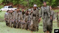 FILE - A group of armed fighters from the Kurdistan Workers Party, or PKK, enter northern Iraq on May 14, 2013. Turkey launched new artillery strikes against the PKK, officials said on July 27, 2024.