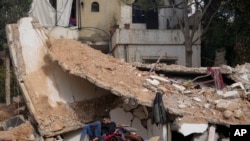 A man sits on the rubble of a destroyed house in Baalbek, eastern Lebanon, Nov. 28, 2024.