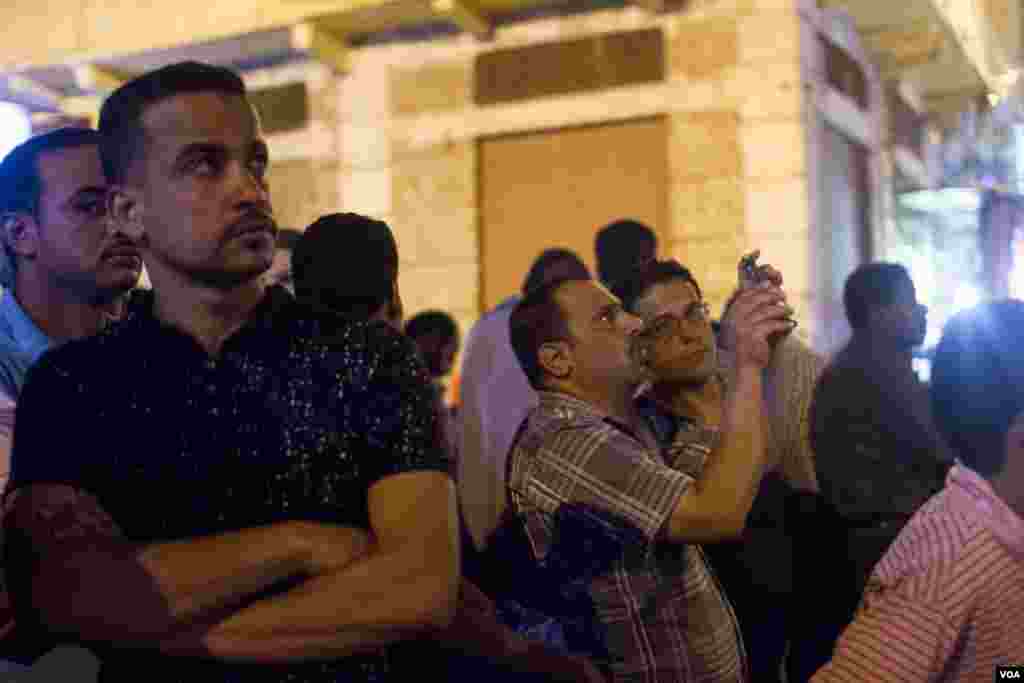 Residents gathered to watch the tilted building of Azareta, “All perpetrators and those responsible for the incident will be held accountable and referred to trial promptly.” Sunday, June 4, 2017. (H. Elrasam/VOA)