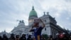 Un manifestante frente al Congreso sostiene un periódico que dice "Milei defraudador", después de una protesta en Buenos Aires, Argentina, el miércoles 26 de febrero de 2025. (Foto AP/Natacha Pisarenko).