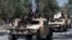 FILE - Armed Taliban fighters parade atop humvee vehicles as they celebrate the first anniversary of the withdrawal of US-led troops from Afghanistan, near the former US embassy in Kabul on Aug. 31, 2022. 
