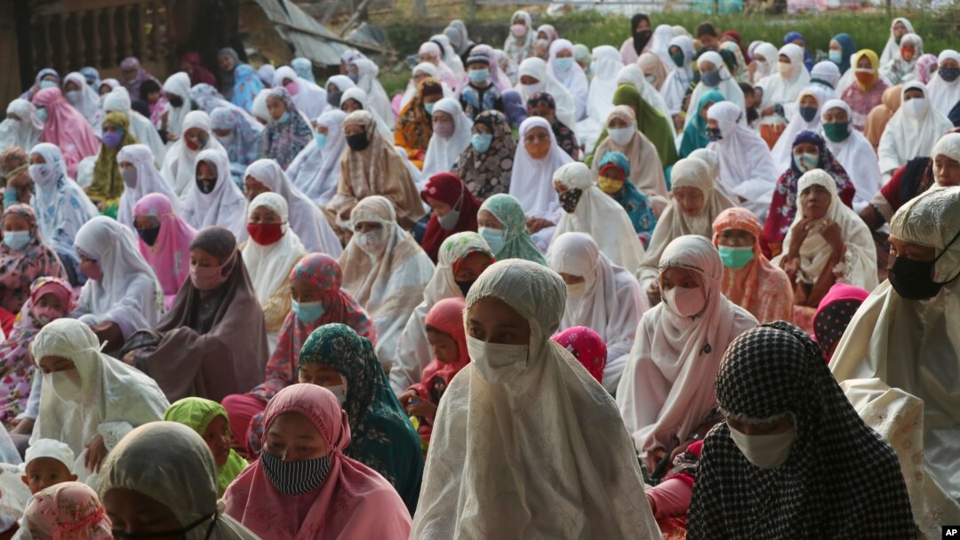 Muslims wear face masks as a precaution against the coronavirus during Eid al-Fitr prayer marking the end of the holy fasting month of Ramadan on a street in in Bekasi, West Java, Indonesia, May 13, 2021.