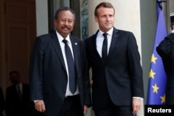 France's President Emmanuel Macron, right, welcomes Sudanese Prime Minister Abdalla Hamdok prior to a meeting at the Elysee palace in Paris, Sept. 30, 2019.