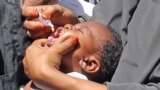 In this May 28, 2013 photo, Somali vaccination workers give an anti-polio drop to a child, in Mogadishu. Somalia. 