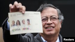 Gustavo Petro muestra una papeleta de votación antes de emitir su voto, en un centro de votación de Bogotá, el 19 de junio de 2022.