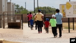 Immigrants seeking asylum leave a cafeteria at the ICE South Texas Family Residential Center, Aug. 23, 2019, in Dilley, Texas.