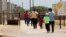 Immigrants seeking asylum leave a cafeteria at the ICE South Texas Family Residential Center, Aug. 23, 2019, in Dilley, Texas.