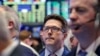 James Matthews, center, works with fellow traders on the floor of the New York Stock Exchange, Oct. 5, 2016.