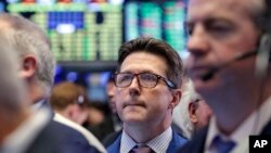 James Matthews, center, works with fellow traders on the floor of the New York Stock Exchange, Oct. 5, 2016.