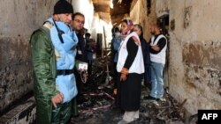 FILE - Afghan (L) talks to staff members in a charred corridor of the damaged Medecins Sans Frontieres (MSF) hospital in northern Kunduz.