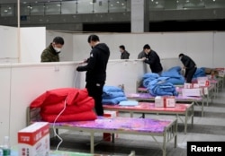 Workers set up infrastructure at the Wuhan International Conference and Exhibition Center to convert it into a makeshift hospital to receive patients infected with the new coronavirus, in Wuhan, Hubei province, China February 4, 2020.