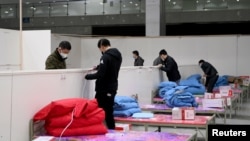 Workers set up infrastructure at the Wuhan International Conference and Exhibition Center to convert it into a makeshift hospital to receive patients infected with the new coronavirus, in Wuhan, Hubei province, China, Feb. 4, 2020. 