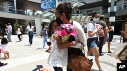 미국 캘리포니아주 산타모니카에서 열린 '어머니의 날' 행사 참가 어린이가 어머니에게 꽃을 안기고 있다. (자료사진)