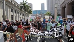 Demonstrators cross over a barricade as they march protesting the death of George Floyd in police custody, in Miami, Florida, May 31, 2020.