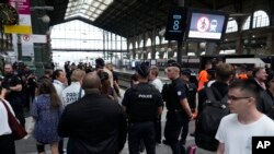 ARCHIVO - Los viajeros esperan mientras la policía patrulla dentro de la estación de tren Gare du Nord en los Juegos Olímpicos el 26 de julio de 2024, en París, Francia, luego de que el tráfico ferroviario de alta velocidad se vio afectado por "acciones criminales" y sabotaje.