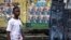 A young man walks in front of election campaign posters for the President of the Democratic Republic of the Congo and leader of the Union of Democracy and Social Progress (UDPS) party, Felix Tshisekedi in Kinshasa on December 14, 2023. 