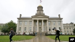 FILE - Students walk past Iowa's Old Capitol on the University of Iowa campus in Iowa City, Oct. 2, 2014. 