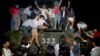 FILE - Civilians with rocks stand on a government armored vehicle near Chang'an Boulevard in Beijing as violence escalated between pro-democracy protesters and Chinese troops, leaving hundreds dead, June 4, 1989.