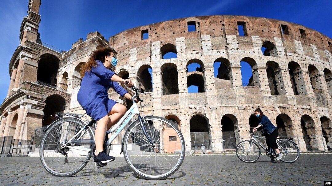 Warga menikmati hari yang cerah di Colosseum, Roma, sementara kasus corona di Italia terus menurun (8/5). 