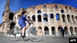 Warga menikmati hari yang cerah di Colosseum, Roma, sementara kasus corona di Italia terus menurun (8/5). 