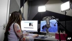 FILE: Web performer Zhang Qige broadcasts a live streaming session at her internet studio in Shanghai. Zhang, a 23-year-old woman who plays computer games and chats online, attracts hundreds of thousands of real-time viewers at once. She has more than 2 million subscribers.