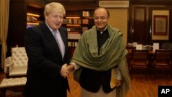 Indian Finance Minister Arun Jaitley greets British Foreign Secretary Boris Johnson in New Delhi, India, Jan. 18, 2017. 
