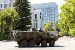 An armored vehicle and a truck block roadway access to the Inter Continental hotel before the arrival of U.S. President Joe Biden, in Geneva, Switzerland, June 15, 2021.